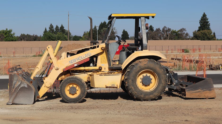 Yellow New Holland backhoe at a construction site in Elk Grove, California.